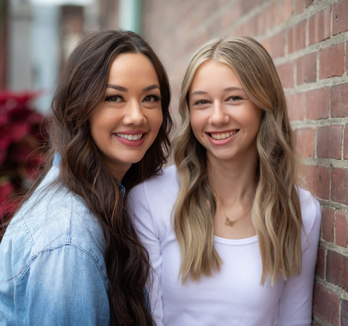 two girls smiling after a molen orthodontics treatment